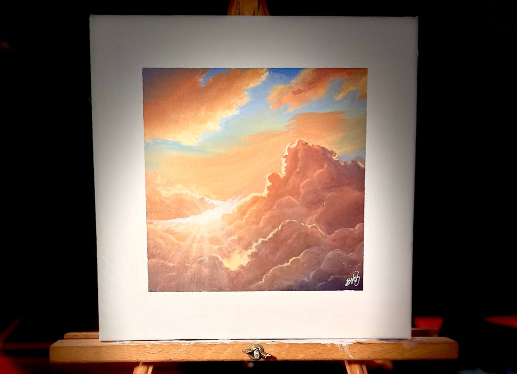 Painting of a sunset with clouds on an easel against a dark background